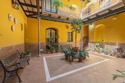 a courtyard with benches and potted plants in a building at Encantador piso Plaza Rivero in Jerez de la Frontera