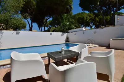 a patio with a table and chairs next to a swimming pool at Recreo de Pilant - Holiday Chiclana in Chiclana de la Frontera