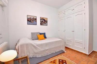 a bedroom with a bed with an orange pillow at Leonita in Chiclana de la Frontera
