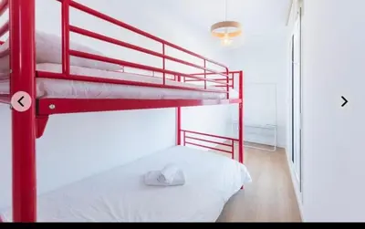 a bedroom with two bunk beds and a white bed at ATICO CALLE FARIÑAS in Sanlúcar de Barrameda