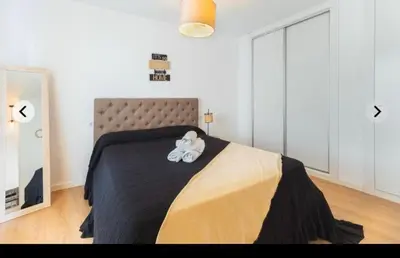 a teddy bear sitting on a bed in a bedroom at ATICO CALLE FARIÑAS in Sanlúcar de Barrameda