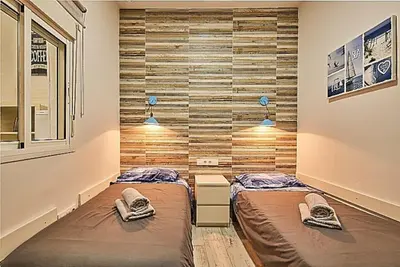 two beds in a room with wooden walls at The Sailors House Ha in Cádiz