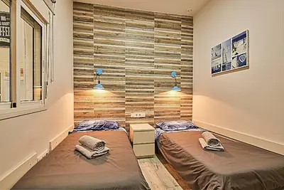 two twin beds in a room with a wall at The Sailors House Ha in Cádiz