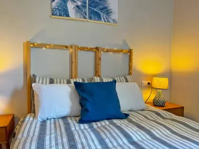 a bedroom with a bed with blue and white pillows at Apartamento Santiago - Ole Solutions in Jerez de la Frontera