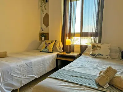 two beds in a room with a window at Apartamento Santiago - Ole Solutions in Jerez de la Frontera