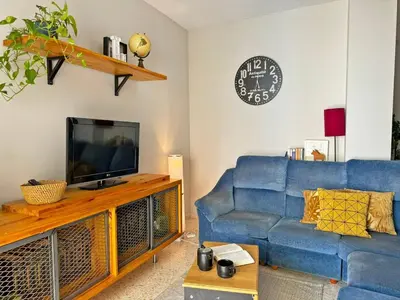 a living room with a blue couch and a tv at Apartamento Santiago - Ole Solutions in Jerez de la Frontera