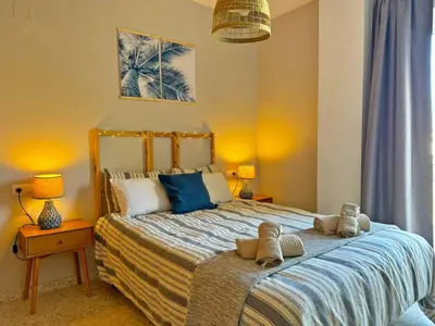 a bedroom with a large bed with towels on it at Apartamento Santiago - Ole Solutions in Jerez de la Frontera
