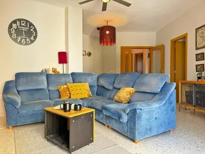 a blue couch in a living room with a table at Apartamento Santiago - Ole Solutions in Jerez de la Frontera