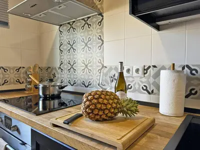 a pineapple on a cutting board on a kitchen counter at Apartamento Santiago - Ole Solutions in Jerez de la Frontera