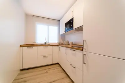 a kitchen with white cabinets and a refrigerator at Fabio Catedral II in Cádiz