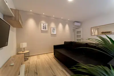 a living room with a black couch and a table at Fabio Catedral II in Cádiz