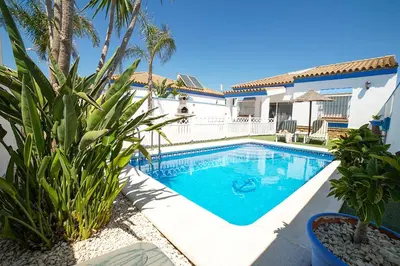 a swimming pool in front of a house at VILLA YUCA CON PISCINA PRIVADA en CONIL DE LA FRONTERA in Conil de la Frontera