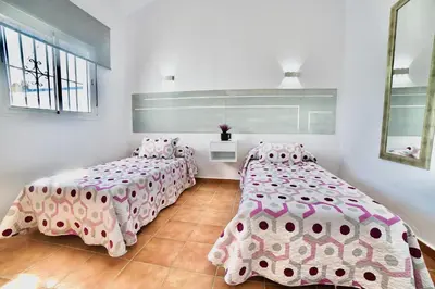 two beds in a room with pink and white sheets at VILLA YUCA CON PISCINA PRIVADA en CONIL DE LA FRONTERA in Conil de la Frontera