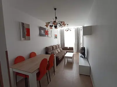 a dining room and living room with a table and chairs at Argentina in Chiclana de la Frontera
