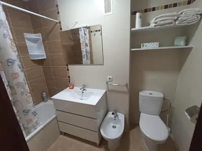 a small bathroom with a toilet and a sink at Argentina in Chiclana de la Frontera