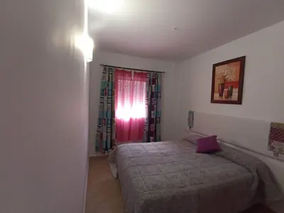 a small bedroom with a bed and a window at Argentina in Chiclana de la Frontera