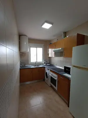 a kitchen with a white refrigerator and a dishwasher at Argentina in Chiclana de la Frontera