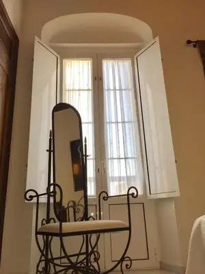 a mirror on a wall next to two windows at Ático con terraza privada en casa Palacio del Centro Histórico in El Puerto de Santa María