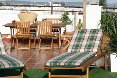 a deck with a table and chairs on a balcony at Ático con terraza privada en casa Palacio del Centro Histórico in El Puerto de Santa María