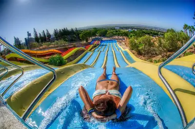 a woman laying on a water slide at a water park at Apartamento playa y centro de Puerto Real - AC - WiFi in Puerto Real