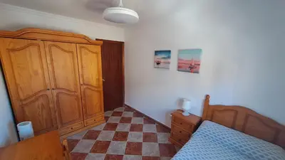 a bedroom with a bed and a wooden cabinet at Apartamento playa y centro de Puerto Real - AC - WiFi in Puerto Real