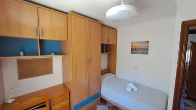 a small room with a bed and wooden cabinets at Apartamento playa y centro de Puerto Real - AC - WiFi in Puerto Real