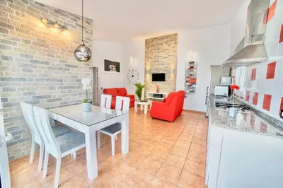 a kitchen and living room with a brick wall at VILLA BANANERA CON PISCINA PRIVADA en CONIL DE LA FRONTERA in Conil de la Frontera