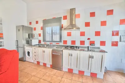 a kitchen with red and white tiles on the wall at VILLA BANANERA CON PISCINA PRIVADA en CONIL DE LA FRONTERA in Conil de la Frontera