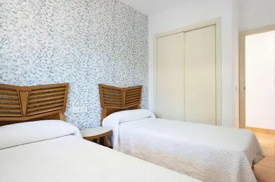 two beds in a room with blue and white wallpaper at Villa Escocia, entre pinares y a pie de playa in Roche