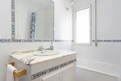 a white bathroom with a sink and a mirror at Villa Escocia, entre pinares y a pie de playa in Roche