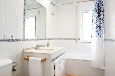 a white bathroom with a sink and a tub at Villa Escocia, entre pinares y a pie de playa in Roche