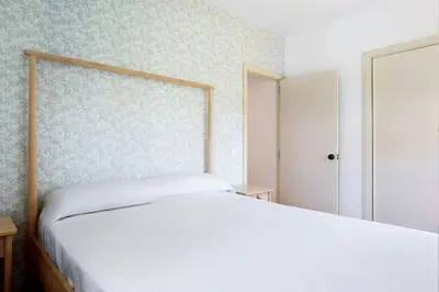 a bedroom with a bed and a blue and white wall at Villa Escocia, entre pinares y a pie de playa in Roche