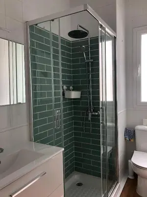 a bathroom with a shower with a green tiled wall at El sueño de Lola in Chipiona