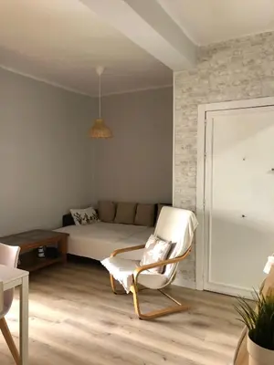 a living room with a bed and a chair at El sueño de Lola in Chipiona