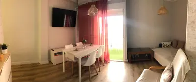 a living room with a table and a bed at El sueño de Lola in Chipiona