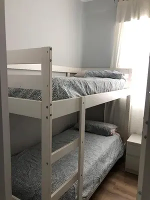 two bunk beds in a room with a window at El sueño de Lola in Chipiona