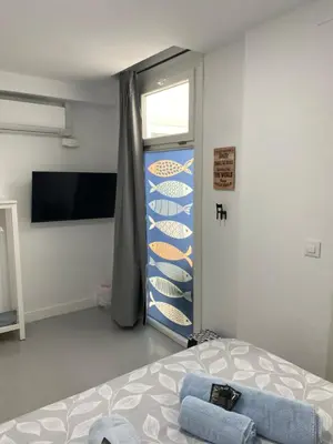 a bedroom with a bed and a tv and a shelf at Sotavento Alpisteras in Sanlúcar de Barrameda