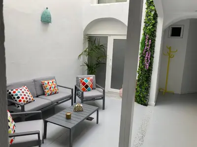 a patio with a couch and chairs and a table at Sotavento Alpisteras in Sanlúcar de Barrameda