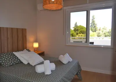 a bedroom with a bed with two pillows and a window at Apartamento Pie de Rey in Jerez de la Frontera