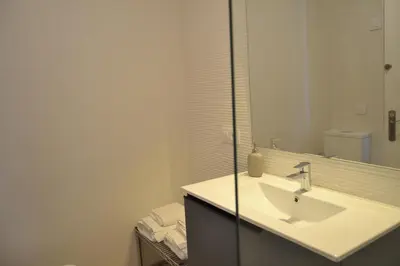 a white bathroom with a sink and a mirror at Apartamento Pie de Rey in Jerez de la Frontera