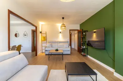a living room with a white couch and a green wall at CR Apartment Jerez in Jerez de la Frontera