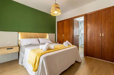 a bedroom with a large bed with a green wall at CR Apartment Jerez in Jerez de la Frontera