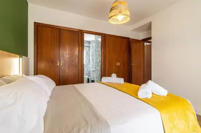 a bedroom with a large white bed with wooden cabinets at CR Apartment Jerez in Jerez de la Frontera