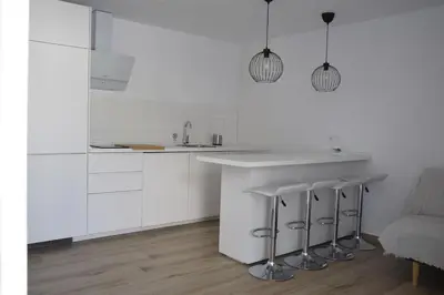 a white kitchen with a counter and stools at Villas Noah in Chiclana de la Frontera