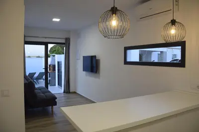 a kitchen with two pendant lights and a living room at Villas Noah in Chiclana de la Frontera