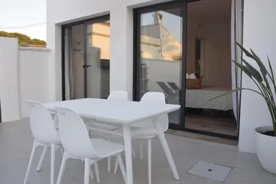 a white table and white chairs on a patio at Villas Noah in Chiclana de la Frontera