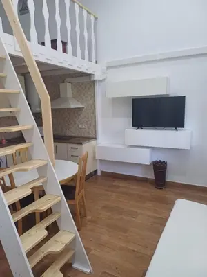a living room with a staircase and a flat screen tv at Loft Ribera Centro Izquierdo in El Puerto de Santa María