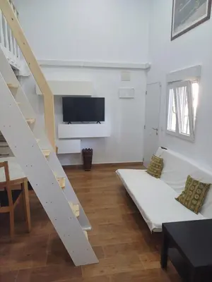 a white living room with a couch and a tv at Loft Ribera Centro Izquierdo in El Puerto de Santa María