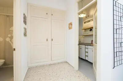 a kitchen with white cabinets and a white door at El Loft de la Reina - Apartamento Interior in Jerez de la Frontera