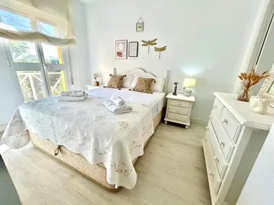 a white bedroom with a bed and a window at GATU LUCIA 3dormit 2 baños terraza aire acc 